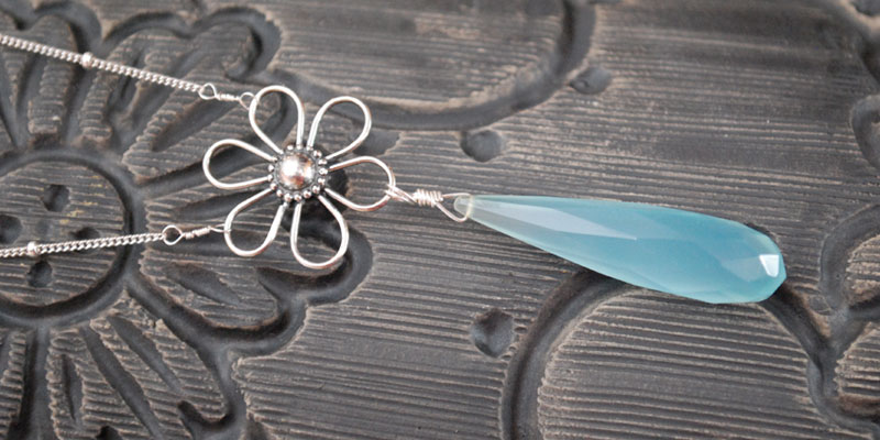 blue chalcedony long tear drop suspended from a flower in sterling silver